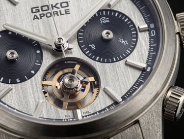 Extreme close-up of a premium mechanical chronograph watch, brushed titanium bezel, complex gears visible, dark studio lighting.