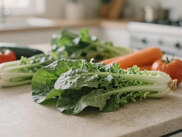 Close-up of fresh, raw ingredients like leafy greens and colorful vegetables on a smooth stone surface, with a blurred background of a kitchen. Soft natural morning light, muted earth and sage tones, shallow depth of field.