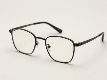 Minimalist thin metal glasses frames in matte black on a clean light-colored background, sharp focus.