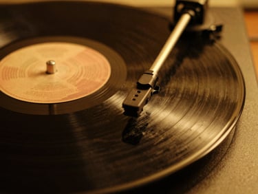 Close-up of a vinyl record spinning under warm golden lighting, shallow depth of field, 35mm film.