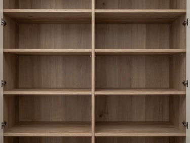 Straight-on shot of an open wardrobe interior, showing grain-matched shelving and flush-fit backing panels, muted natural oak.