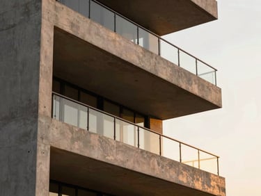 Close-up architectural detail of a modern luxury penthouse balcony in Noida, clean concrete lines, warm sunset lighting, editorial style