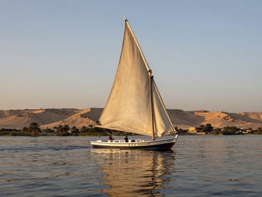 Low-angle golden hour shot of a traditional wooden felucca sailing on the calm Nile river, soft warm light reflecting off the water, empty desert hills in the background.