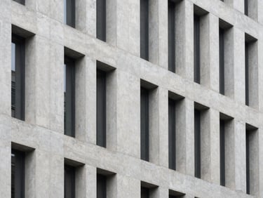 High-angle architectural shot of a modern concrete building facade, sharp focus, desaturated cool tones