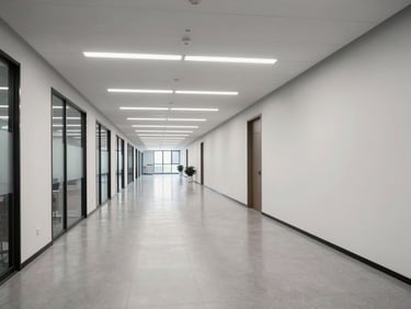 Wide environmental shot of a spotless commercial office corridor, even overhead lighting, hard floors reflecting ceiling fixtures, empty of people, architectural lines sharp and clean