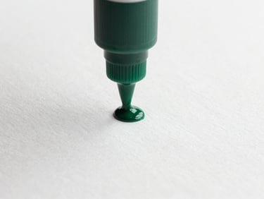 Close-up of forest green soy-based ink being pressed onto textured white paperboard, high-contrast minimal studio shot