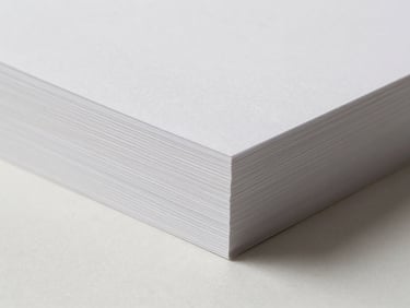 Close-up of premium thick white paperboard edge showing precise caliper thickness, soft diffused studio light, 85mm