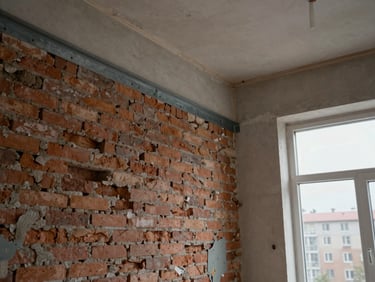 Detail view of a renovation in progress — stripped interior wall exposing original brick and new steel lintel, Novosibirsk apartment block context visible through a window, overcast daylight