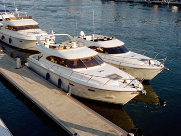 Gleaming boats docked at pristine covered slips under warm morning light, clean concrete docks, 35mm
