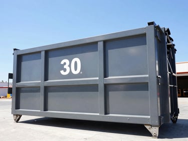 Low-angle heroic shot of a clean, branded 30-yard roll-off dumpster at a commercial development, bright California daylight, sharp focus.