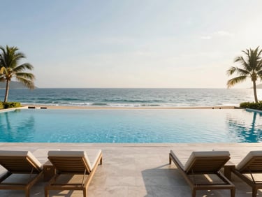 A wide-angle shot of a pristine infinity pool overlooking the ocean at golden hour, luxury lounge chairs neatly arranged.