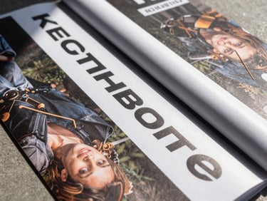 Overhead flat-lay of printed promotional banners and rollup displays neatly stacked, foil finish visible under north-facing daylight, material texture sharp and clear