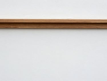 A crisp, freshly painted white wall meeting a clean wood trim corner, showing precise lines and no blemishes.