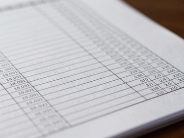 Macro close-up of structured financial ledgers and precise document lines under soft, professional office lighting.