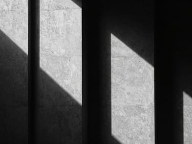 Stark black and white architectural shadow play on concrete walls, minimalist geometry, sharp contrast, cinematic