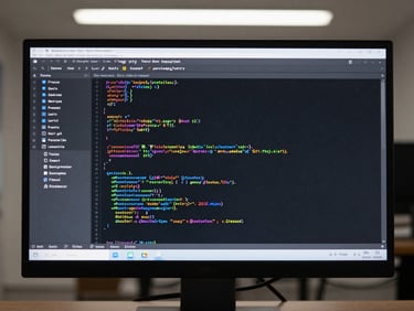 Game code repository open on a monitor screen, syntax-highlighted source files visible, clean overhead studio lighting, no person visible, no device mockup framing