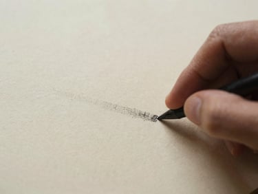 Close up of fingers smudging charcoal lines on rough cream paper, soft diffused side light, warm earthy tones