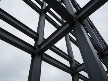 Extreme wide-angle shot of structural steel beams of a modern skyscraper under a cool overcast sky, high-contrast architectural shadows, geometric precision