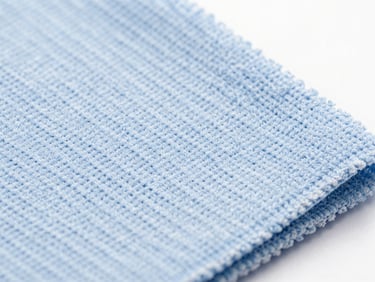 Macro close-up of a blue micro-fiber cleaning cloth, showing intricate weave, under clinical studio light