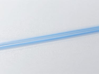 Abstract image of static charge dissipating from a surface, represented by subtle blue lines on a sterile gray background, clinical lighting