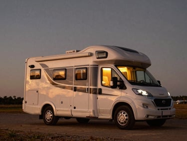 A luxury triple-axle motorhome parked under a starry night sky, warm interior lights glowing, premium VIP travel aesthetic