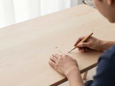 A person assembling a pastel wood desk with simple tools, focused on the connection points, bright daylight.