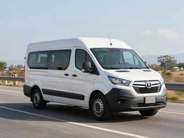 Wide environmental shot of a modern white corporate van driving on a clean Colombian highway under bright morning light, professional framing, 35mm lens