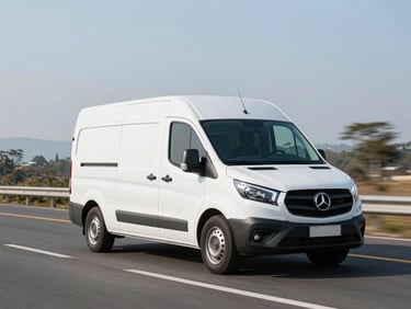 Wide environmental shot of a modern white corporate van driving on a clean Colombian highway during crisp morning light, professional framing, 35mm lens