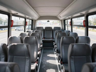Interior of a modern clean passenger bus, plush gray seats, spacious aisle, bright daylight shining through large clean windows, professional corporate photography