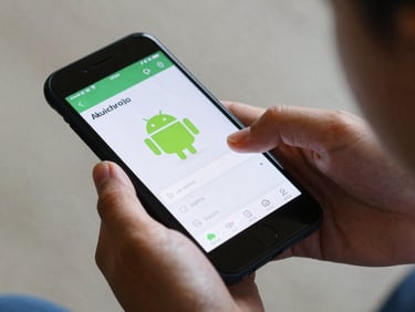 A child's hand interacting with a native Android application on a physical phone, displaying high-contrast UI elements, soft natural lighting.