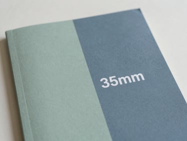 Clean, minimalist cover of a psychological first aid manual, with a calm abstract design in slate blue and sage green, soft diffused natural light, muted compassionate tones, shallow depth of field, 35mm