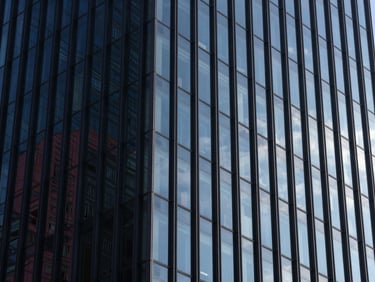 Abstract architectural perspective of steel and glass high-rise facade, sharp morning daylight reflecting deep navy tones, high-contrast composition, Hasselblad medium format.