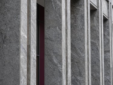 Tight abstract macro shot of premium grey marble and steel architectural columns in a modern financial headquarters lobby, sharp focus, crisp daylight