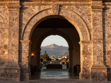 Colonial stone archway view looking into a high-end modern interior, warm ambient light, refined Cusco heritage details