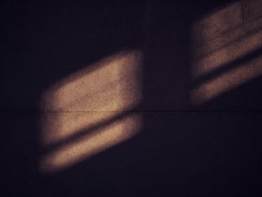 Abstract architectural shadow play on a concrete wall, with a subtle golden light streak, cinematic dark luxury, high contrast