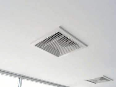 Straight-on architectural shot of modern commercial ceiling ventilation grilles, bright natural daylight, high-key white exposure.