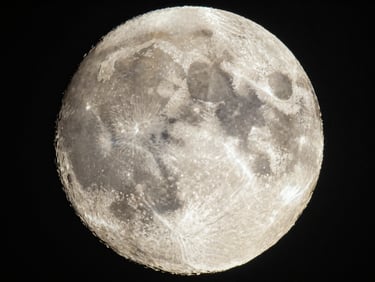 Ultra-sharp telephoto close-up of the moon's surface during a lunar transit, detailed craters, dark sky, fine art astrophotography
