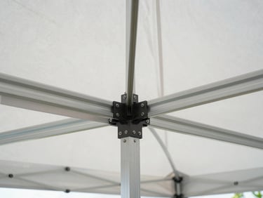 Symmetrical close-up of heavy-duty aluminum tent framing and clean white canvas canopy, highlighting structural integrity, crisp morning daylight, architectural precision.