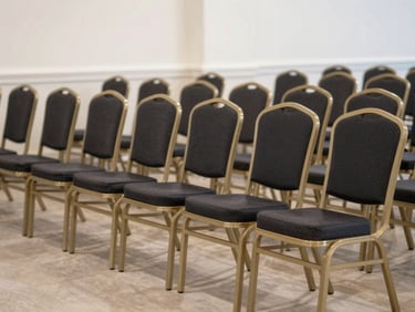 A perfectly aligned row of premium banquet chairs and structured event furniture inside a clean, bright hall.