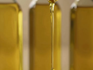 Close-up of golden vegetable oil pouring smoothly, warm golden-hour light, professional food photography, rich olive and gold tones, medium format