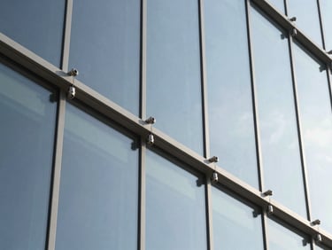 Close-up of stainless steel spider fittings anchoring a large-span glass façade, sharp architectural shadows, technical engineering, 35mm