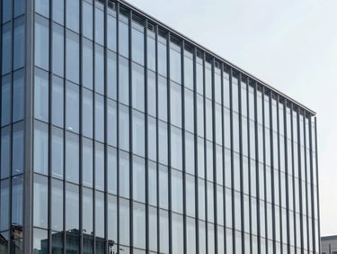 Exterior elevation of a modern commercial building showing a continuous glass curtain wall, sharp structural lines, minimal luxury, 35mm