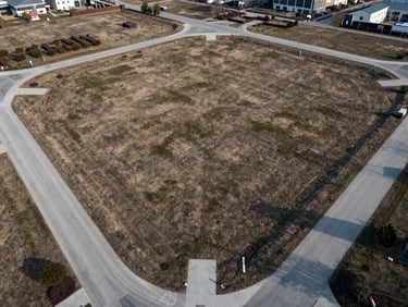 Aerial drone perspective of a clean, structured land lot development with visible road layouts.