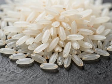 Macro close-up of long-grain Basmati rice on a clean, dark industrial surface, highlighting uniform length, pristine white color, and absence of defects under bright white laboratory light.