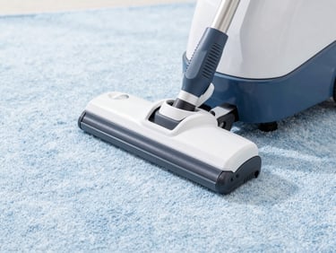 Close-up of a professional carpet extractor machine on a clean carpet, soft blue tones, bright high-key commercial photography, crisp white and soft blue tones, sharp focus, 35mm lens.