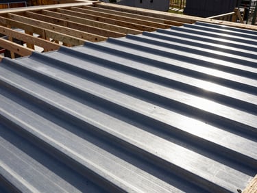 Completed heavy-duty metal roofing installation with reinforced structural timber framing, bright directional sunlight, sharp details