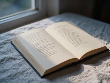 A poetry book lying open on a soft linen sheet, showing elegant typography on textured cream paper, lit by warm evening light.