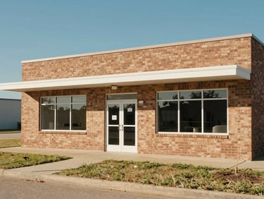 A clean, well-lit rural Texas clinic exterior under bright sunlight, showing a modern brick facade and a clear blue sky.
