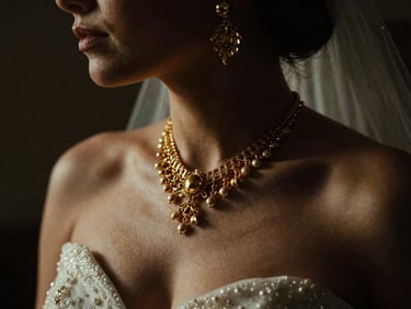 Stylized editorial shot of a bride with golden accessories, dramatic low-key lighting, deep shadows, warm golden accents, rich contrast, cinematic wedding photography, 35mm film grain, tight crop on details.