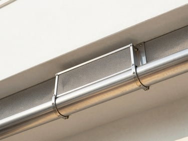 Macro close-up of a high-quality stainless steel micro-mesh gutter guard installed on a seamless gutter, clean joints, natural daylight.